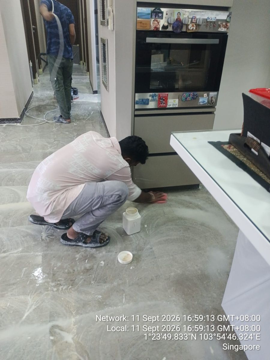Technician filling chips in a marble floor with colour-matched resin